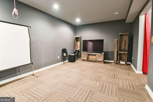 carpeted cinema room with a fireplace