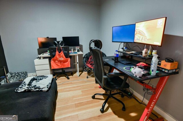 home office with light hardwood / wood-style flooring