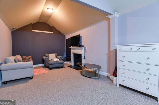 carpeted living room with vaulted ceiling and decorative columns