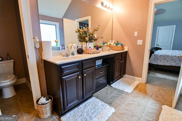 bathroom featuring tile patterned flooring, toilet, and vanity