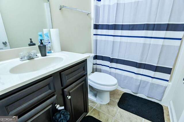 bathroom featuring vanity, toilet, a shower with curtain, and tile patterned floors