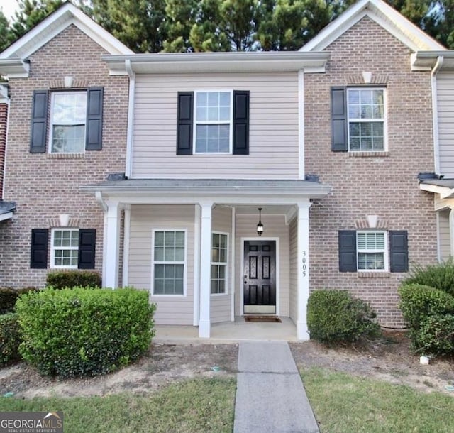 view of front of house with a porch and brick siding