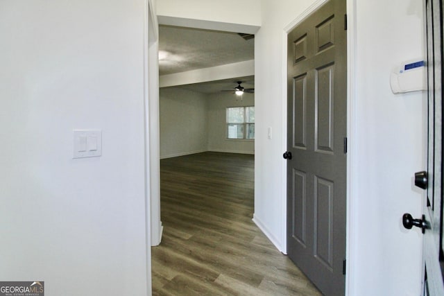 hallway featuring baseboards and wood finished floors