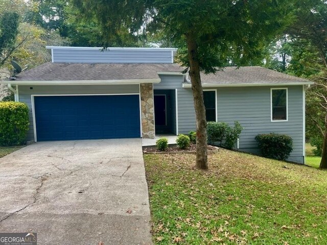 ranch-style home with a front yard and a garage