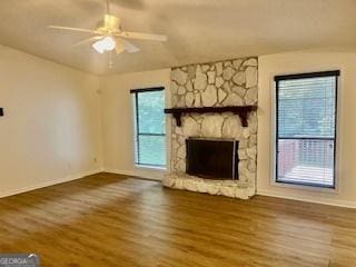 unfurnished living room with hardwood / wood-style flooring, plenty of natural light, ceiling fan, and a fireplace