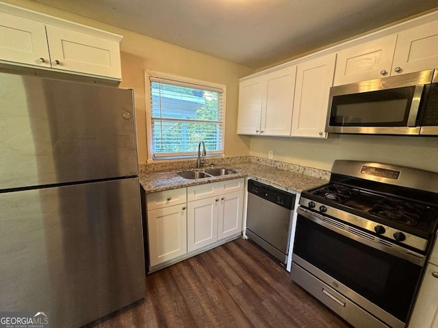 kitchen with white cabinetry, light stone counters, sink, dark hardwood / wood-style floors, and appliances with stainless steel finishes