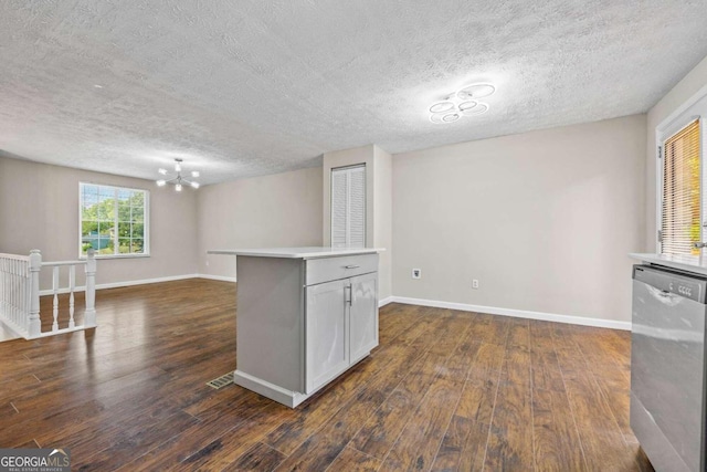 basement with a textured ceiling, a notable chandelier, and dark hardwood / wood-style floors