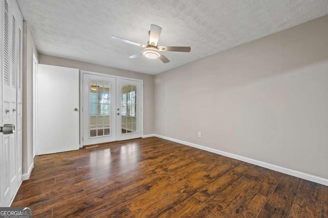 empty room featuring french doors, a textured ceiling, ceiling fan, and dark hardwood / wood-style floors