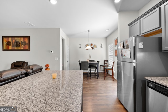 kitchen featuring appliances with stainless steel finishes, light stone countertops, dark wood-type flooring, visible vents, and recessed lighting