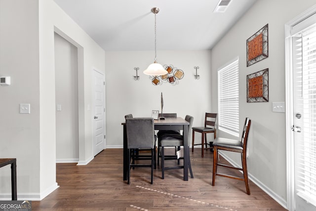 dining space with wood finished floors, visible vents, baseboards, and plenty of natural light