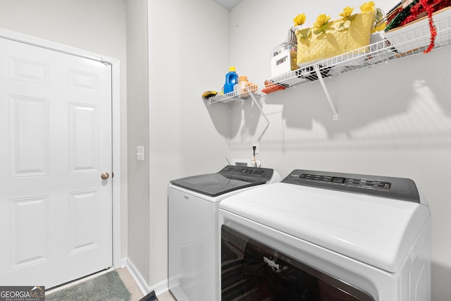 laundry room with washing machine and dryer, baseboards, and laundry area