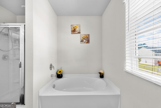 bathroom with a garden tub and a shower stall
