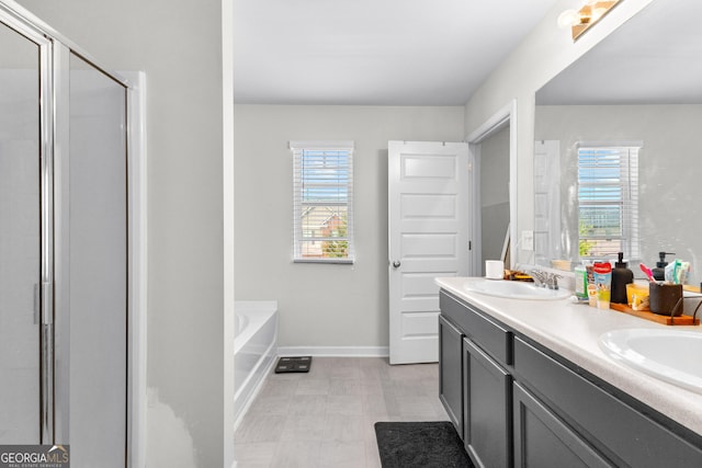 bathroom with double vanity, a shower stall, tile patterned floors, and a sink