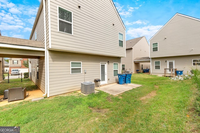 rear view of house featuring fence, a lawn, a patio, and central AC unit