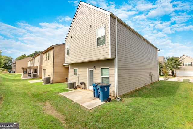 rear view of house with cooling unit, a yard, and a patio area