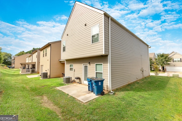 back of house with central AC, a patio, and a lawn