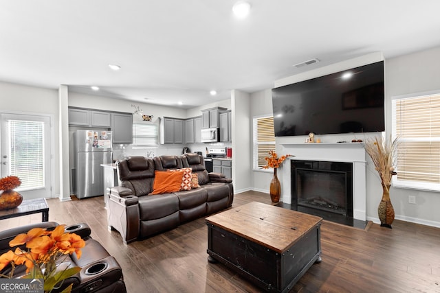 living area with recessed lighting, wood finished floors, visible vents, baseboards, and a fireplace