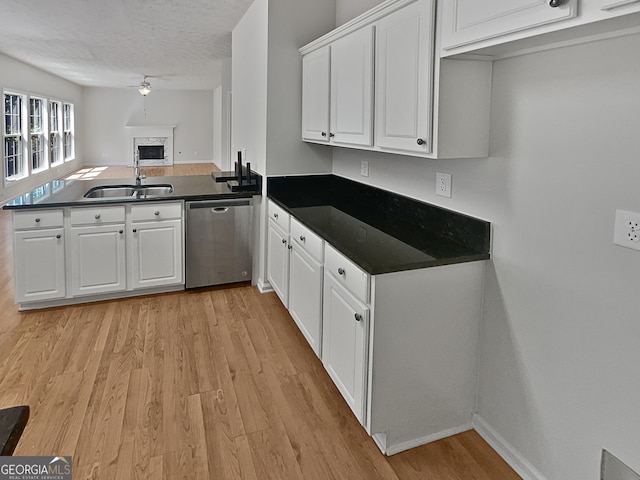 kitchen featuring dishwasher, kitchen peninsula, sink, white cabinets, and light hardwood / wood-style floors