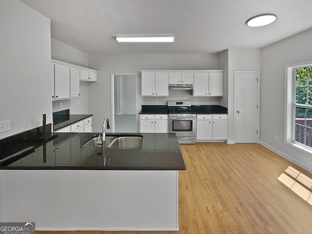 kitchen with stainless steel gas stove, light wood-type flooring, sink, and white cabinets