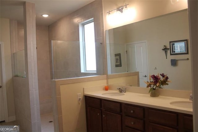 bathroom featuring a tile shower, plenty of natural light, and vanity