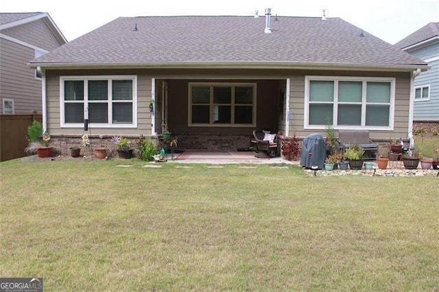 rear view of house featuring a yard and a patio