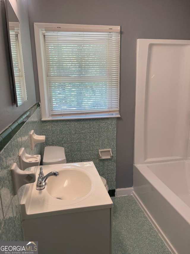 full bathroom featuring vanity, toilet, plus walk in shower, and decorative backsplash