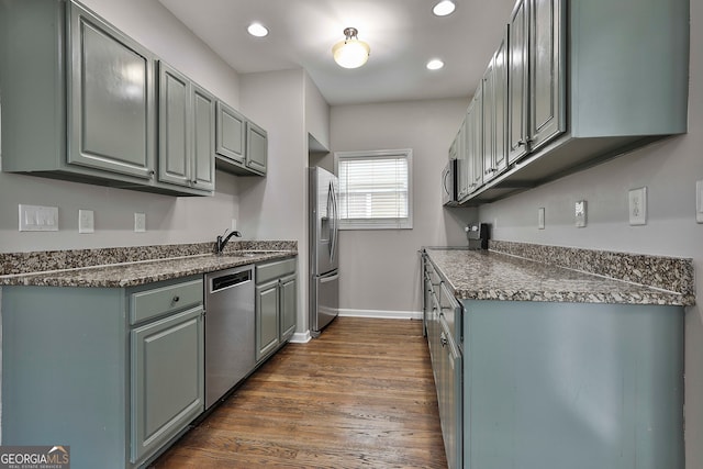 kitchen featuring appliances with stainless steel finishes, dark hardwood / wood-style flooring, and sink