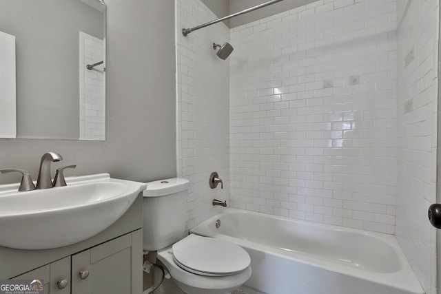 full bathroom featuring tiled shower / bath, vanity, and toilet