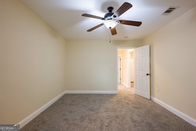 carpeted spare room with ceiling fan