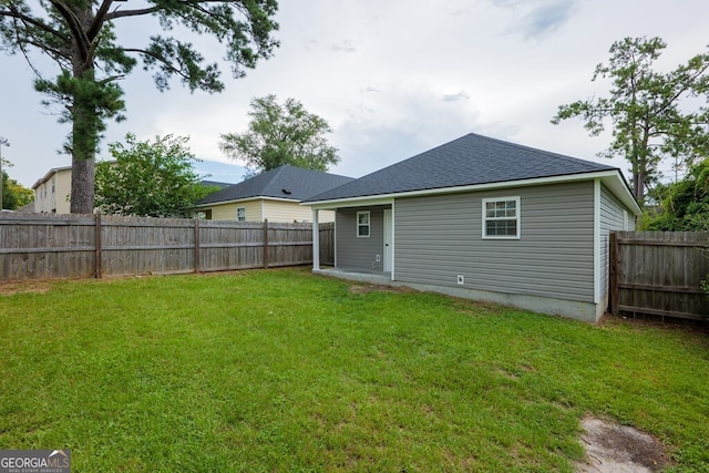 rear view of house featuring a yard