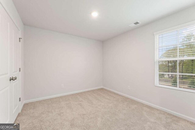 empty room with a wealth of natural light and light colored carpet