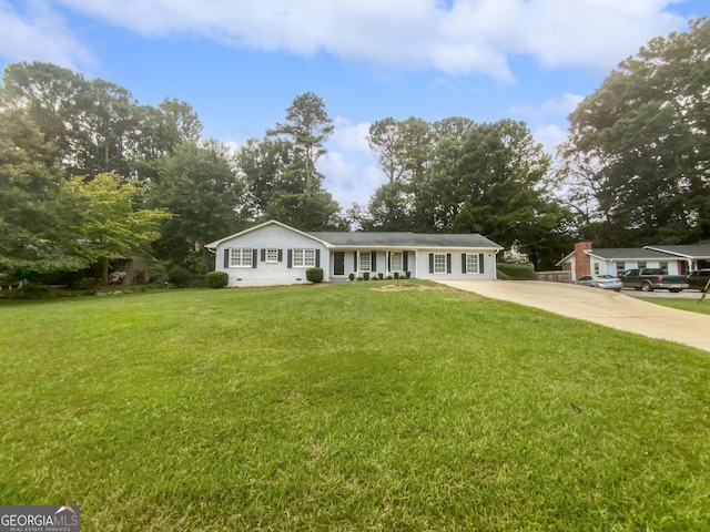 ranch-style home featuring driveway and a front lawn