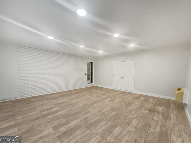 interior space with brick wall and light hardwood / wood-style floors