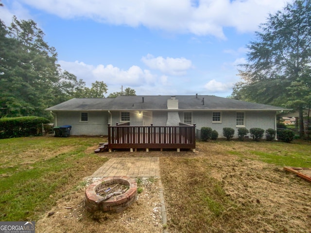 720 Smithstone Rd SE, Marietta, GA 30067 - back of house featuring an outdoor fire pit, a deck, brick siding, and a lawn
