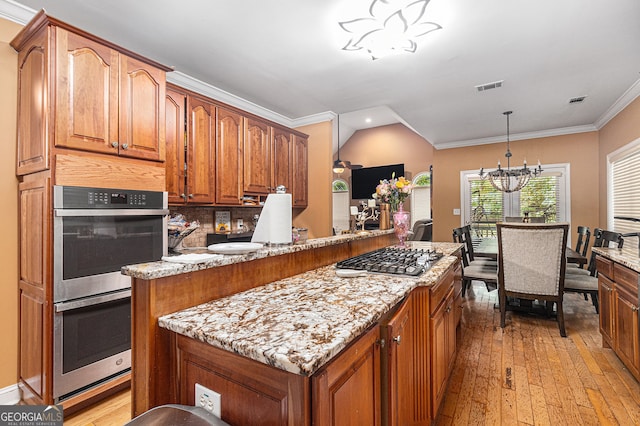 kitchen with light hardwood / wood-style floors, light stone counters, an inviting chandelier, and hanging light fixtures