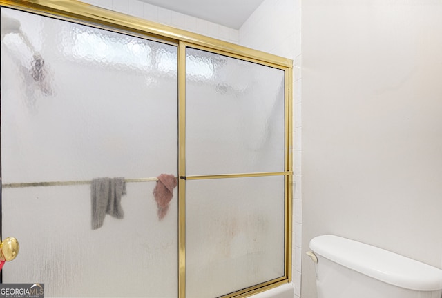 bathroom featuring an enclosed shower and toilet