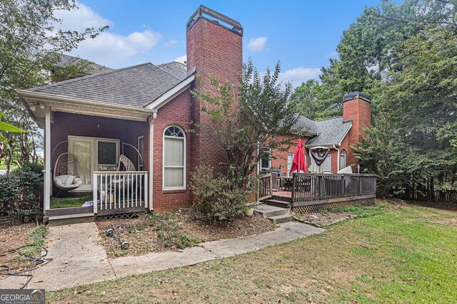 view of front of property featuring a front yard and a deck