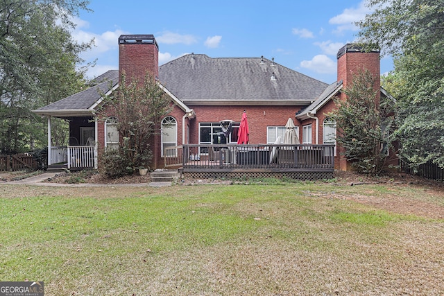 back of property with a lawn and a wooden deck