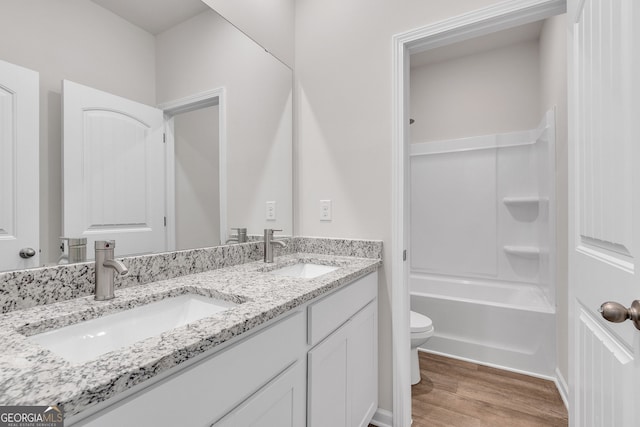 full bathroom featuring hardwood / wood-style floors, shower / bath combination, toilet, and vanity