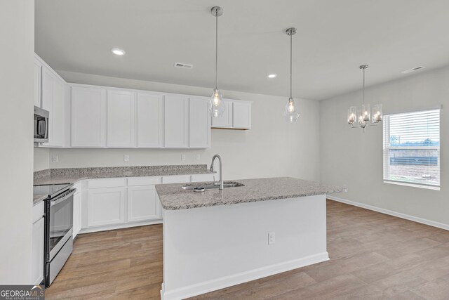 kitchen with light hardwood / wood-style flooring, stainless steel appliances, a kitchen island with sink, and white cabinetry