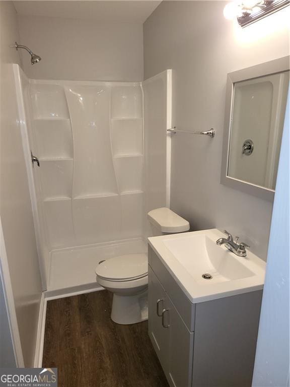 full bathroom featuring hardwood / wood-style floors, toilet, shower / bathing tub combination, and vanity