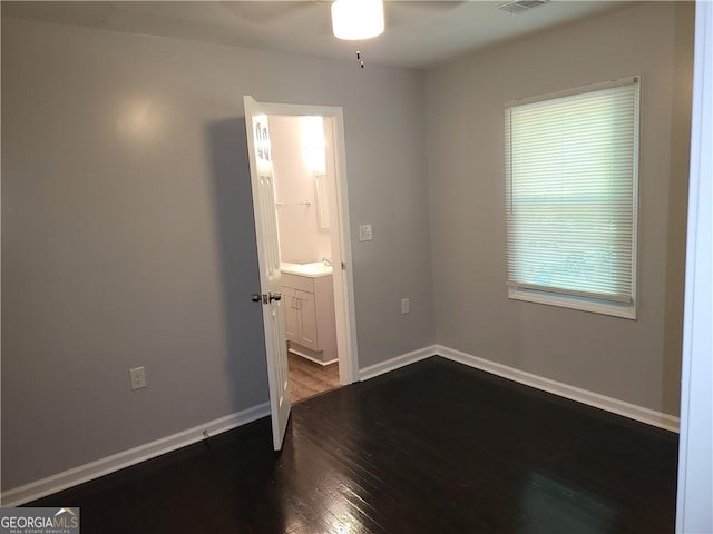 unfurnished room with dark hardwood / wood-style flooring and ceiling fan