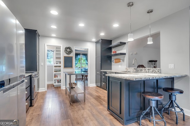 kitchen featuring decorative light fixtures, open shelves, electric range, a sink, and a peninsula