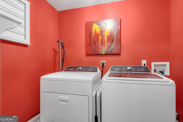 washroom with a textured ceiling, laundry area, and independent washer and dryer