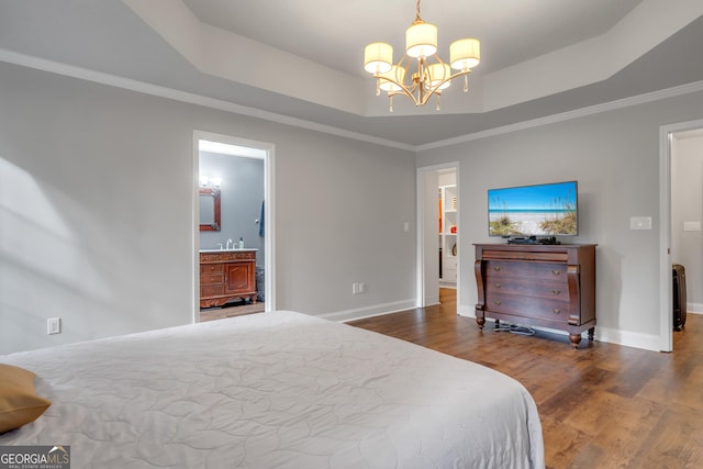 bedroom featuring baseboards, a notable chandelier, a tray ceiling, and wood finished floors