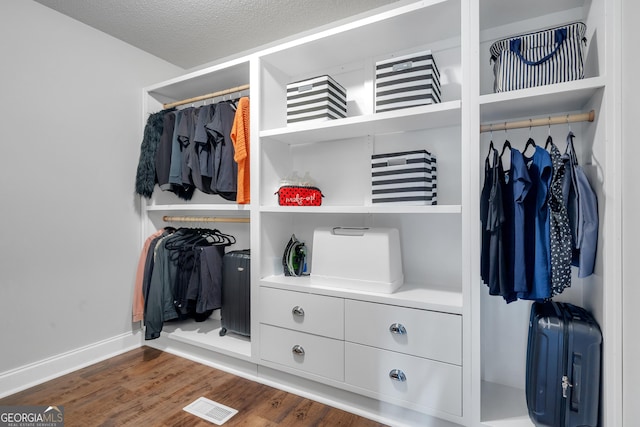 spacious closet featuring dark wood-style floors and visible vents