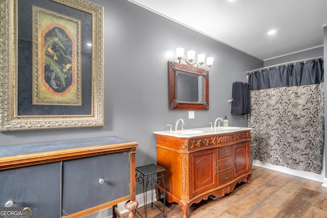 full bathroom featuring a sink, wood finished floors, baseboards, a shower with curtain, and double vanity