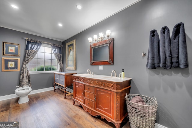 full bathroom featuring double vanity, a bidet, a sink, wood finished floors, and baseboards