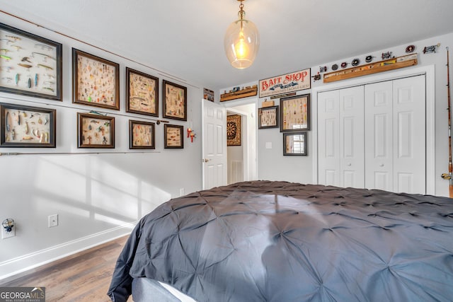 unfurnished bedroom with a closet, baseboards, and wood finished floors