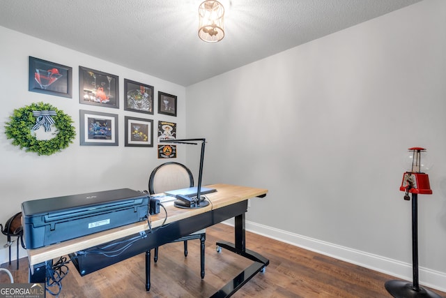 office space with a textured ceiling, baseboards, and wood finished floors